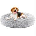 Beagle resting in the light grey CalmCurl calming donut bed