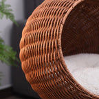 Close view of the woven pod and plush cushion of the wicker egg chair cat bed