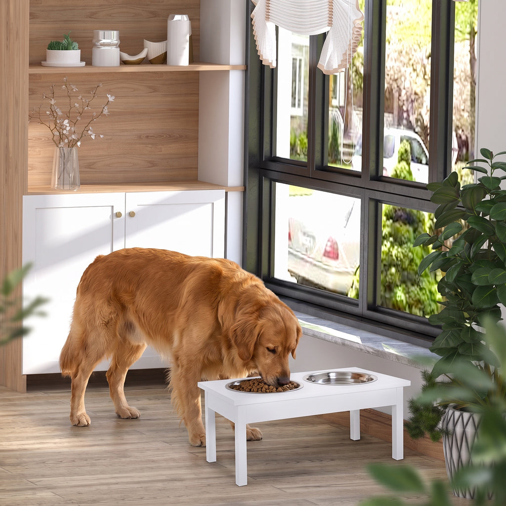 Golden retriever eating from a white elevated feeding station with two stainless steel bowls