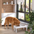 Golden retriever eating from a white elevated feeding station with two stainless steel bowls