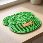 Close view of the textured zones of the green lick mat with peanut butter worked into the pattern
