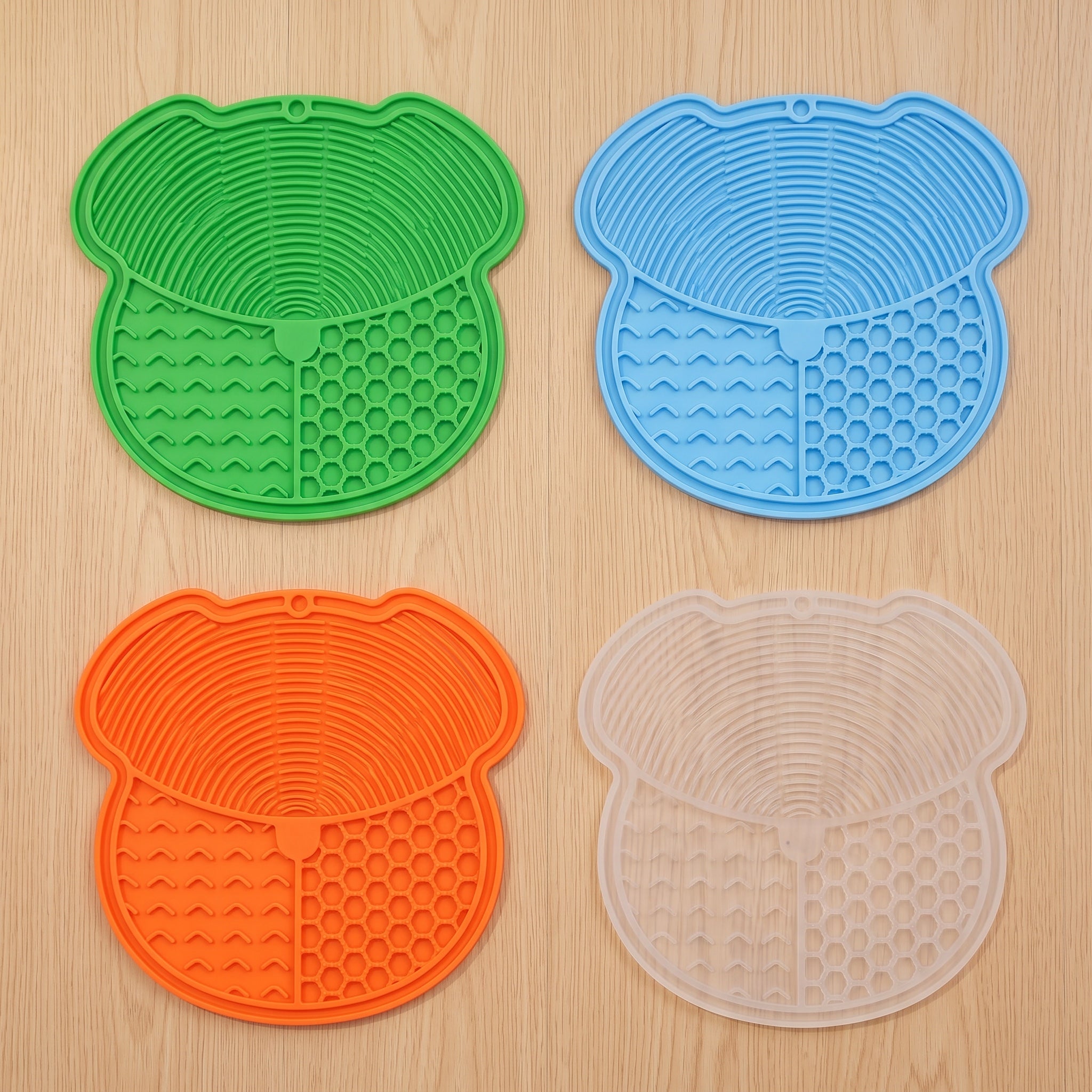All four lick mat colors laid flat: green, blue, orange and transparent