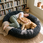 Woman and golden retriever napping together in the dark grey CalmCurl Den