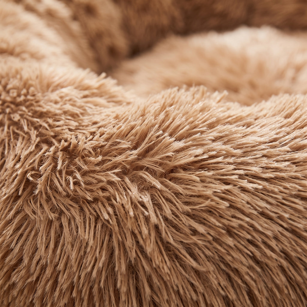 Close-up of the CalmCurl bed faux-fur texture, individual plush strands in warm light