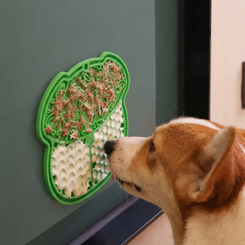 Green :: Dog licking food from the green CalmCurl lick mat suction-mounted on a smooth surface